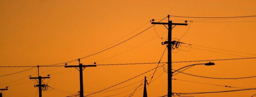 silhouettes of the power lines and wires in a residential neighborhood backlit by the evening sky HYu4Qv0ro